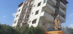 İş makinesinin tek darbesiyle yerle bir oldu! Hatay'da depremde hasar alan binanın yıkılma anı kamerada